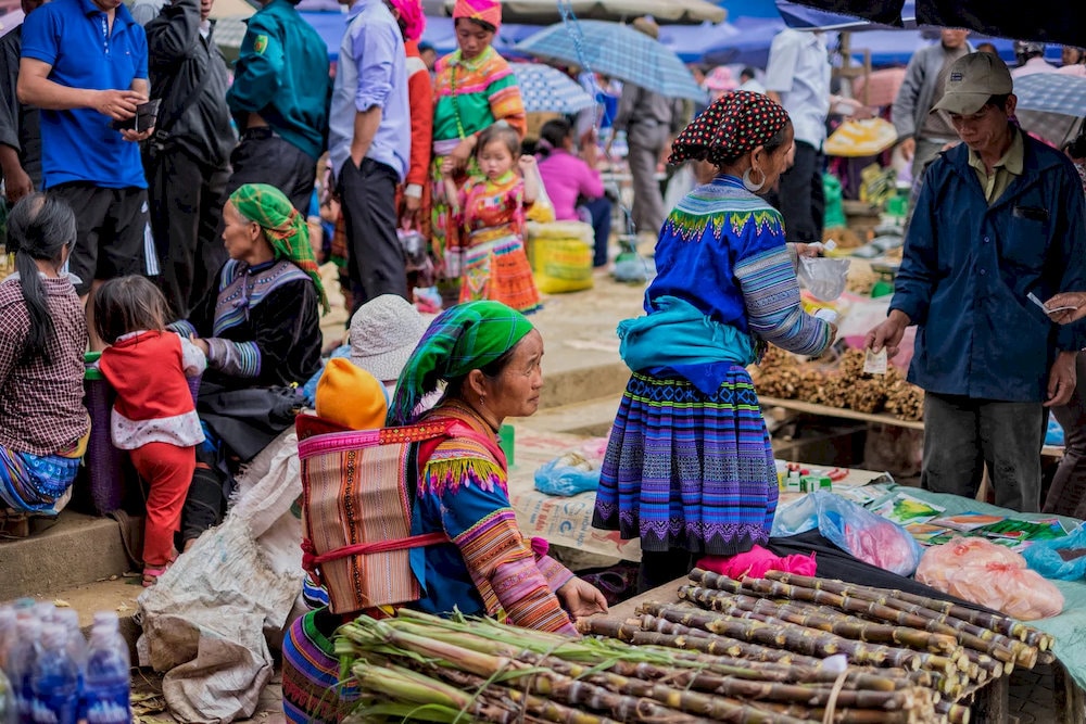 Explore bustling local markets in Sapa where ethnic minority vendors sell fresh produce, traditional textiles, and authentic handicrafts 